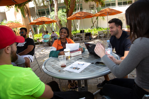 Students talking at a patio table