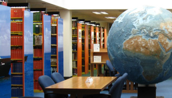 Library shelves, tables, and a globe statue
